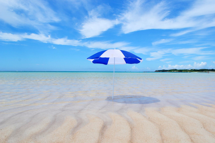 ヨロン島の白い砂浜に立つパラソルの写真